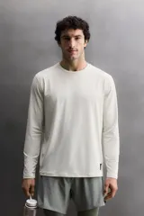 Camiseta de entrenamiento de manga larga y cuello redondo, confeccionada en tejido técnico ligero y elástico con tecnología de secado rápido. Presenta costuras planas para mayor resistencia y comodidad durante el movimiento, con un pequeño logo estampado en el bajo.