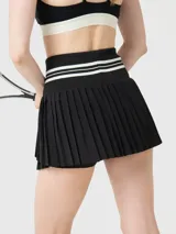 Falda tipo skort con diseño plisado y cintura alta elástica con detalles de rayas blancas. Incluye short integrado con bolsillo, confeccionada en tejido técnico de secado rápido.
