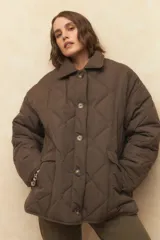 Campera capitoneada negra con botones veteados, bolsillos laterales de solapa y forro de satén con estampado animal print.