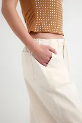 Pantalon cargo color beige de corte recto, con bolsillos laterales y cordón ajustable en la cintura.