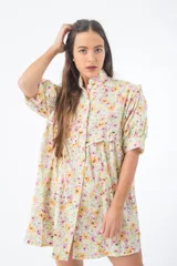 Vestido corto verde con estampado floral, cuello alto, mangas cortas abullonadas y corte holgado.