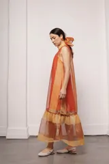 Vestido largo color ocre con estampado de cuadrados dorados, cuello alto y corte amplio. Incluye viso liso al tono.