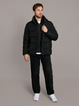 Campera acolchada Calvin Klein de color negro, con diseño matelasseado, cuello alto, cierre frontal con cremallera y bolsillos laterales con cierre. Incluye chaleco interior desmontable.
