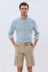 Bermuda cargo color azul marino, de gabardina con bolsillos laterales con solapa en las piernas y presillas para cinturón. Incluye cinturón de lona trenzada oscura con detalles en cuero sintético y hebilla metálica.