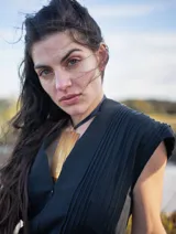 Mono color arena de lino, con cuello mao, cierre frontal con cremallera, mangas cortas y cinturón de lazo.