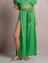 Pantalón palazzo de lino color azul, de tiro alto con cintura elastizada y cinto lazo incorporado con cuentas decorativas en las puntas. Presenta aberturas laterales pronunciadas en las piernas y corte amplio.