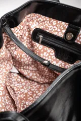 Bolso tipo tote de gran tamaño en color bordó con acabado brillante. Cuenta con doble asa de hombro y placa metálica decorativa con logo en la parte frontal.