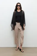 Ruana de tejido abierto con hilo de lurex dorado, diseño amplio y caída ligera.