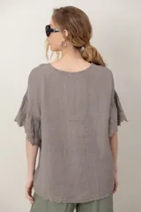Blusa de lino color tostado, de corte holgado y manga corta con inserción de puntilla bordada.