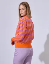 Cardigan de punto con rayas horizontales en tonos azul marino, gris, blanco y rosa. Escote en V y cierre frontal con botones dorados.