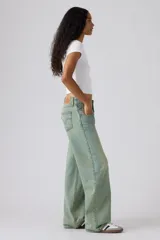 Pantalón de jean de tiro muy bajo con corte holgado y diseño de canesú en la cintura. Presenta un lavado desgastado en tono azul claro con costuras visibles.