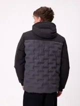 Campera con capucha, diseño bicolor en negro y gris oscuro, con panel frontal acolchado y mangas lisas. Cuenta con cierre frontal, bolsillos laterales y puños elásticos.