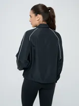 Campera cortaventos Umbro de diseño colorblock en tonos celeste, beige y azul marino, con cuello alto, cierre frontal y bolsillos laterales.