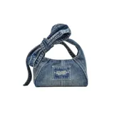 Bolso Marc Jacobs modelo The Bow Denim Mini Sack, confeccionado en denim azul con lazo decorativo extragrande. Cuenta con asa superior y correa cruzada ajustable de cuero.