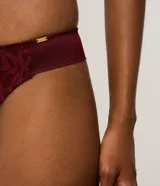 Conjunto de lencería compuesto por un corpiño tipo bralette con aros y una bombacha tipo bikini, ambos confeccionados en encaje con diseño geométrico en color bordó.
