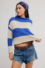 Sweater de punto grueso a rayas anchas azules y beige, de calce corto y amplio, con cuello alto vuelto y mangas caídas.