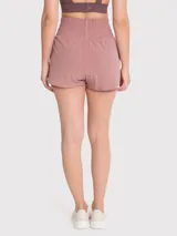 Short deportivo de tiro alto con calza incorporada, pretina ancha elástica y bolsillo lateral. Diseño de doble capa con ajuste regular.