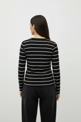 Remera de manga larga ajustada al cuerpo, color marrón con rayas horizontales blancas, cuello redondo.