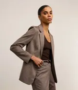 Blazer slim de punto roma color marrón con cuello solapa, abotonado delantero de botón doble forrado, bolsillos tipo cuchillo y manga larga.