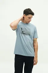 Remera de manga corta en color celeste con estampado fotográfico en el pecho y cuello redondo. Presenta un corte regular y diseño clásico.
