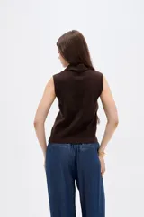 Chaleco de punto sin mangas con cuello polo, diseño de rombos estilo argyle en tonos marrón, negro y beige.