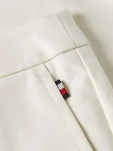 Pantalón corto blanco con cinturón de rayas horizontales rojas, blancas y negras, con hebilla metálica.