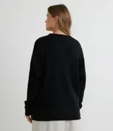 Suéter de punto texturizado con cuello redondo y mangas largas con sisa caída. Presenta un diseño liso y holgado, ideal para un estilo casual y versátil.