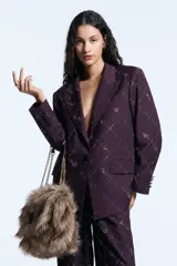 Blazer de sarga color bordó con corte oversize, hombreras marcadas y cierre frontal con un botón forrado a tono. Presenta un diseño estampado de cuadrícula con detalles de hotfix y bolsillos frontales con solapa.