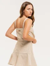 Musculosa de lino a rayas verticales azules y blancas, con breteles anchos y ruedo con flecos.