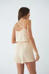 Mono corto de tirantes finos con escote en V, cintura elástica con cordón ajustable y espalda descubierta.