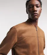 Chaqueta bomber azul marino lisa, con cierre frontal, cuello redondo y bolsillos laterales.