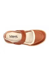 Zapato tipo guillermina de cuero, con diseño combinado en tonos marrón y beige. Presenta cierre con tira de velcro en el empeine, costuras decorativas visibles y suela plana de goma en color tostado.