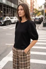 Remera de algodón negro con mangas cortas abullonadas, cuello redondo y costura central frontal.