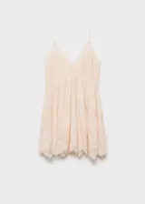 Vestido corto color crema con breteles finos y escote en V con encaje.