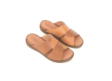 Sandalias de cuero color caramelo, con tiras cruzadas en el empeine, plataforma baja y suela de poliuretano flexible.