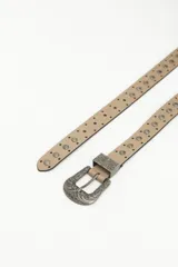 Cinto color beige de cuero sintético con tachas metálicas plateadas y hebilla metálica con diseño labrado.