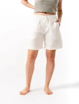 Shorts de lino color blanco, con cintura elástica ajustable con cordón, dos bolsillos laterales y un bolsillo trasero.