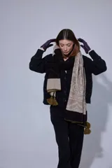 Chal de lana con diseño de patrón paisley y detalles de tejido en punto. Presenta terminaciones con pompones en los extremos.