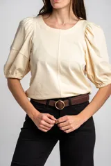 Remera de algodón negro con mangas cortas abullonadas, cuello redondo y costura central frontal.