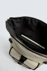 Mochila verde militar con acabado engomado, solapa superior con cierre de hebilla y cremallera, bolsillo frontal con cierre imantado, compartimento interno para laptop de hasta 13 pulgadas, asa de mano superior, correas de hombro ajustables y espalda acolchada. Base de cuero sintético negro.