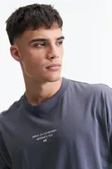 Remera gris de manga corta con corte boxy y estampado en la espalda con una rosa y texto en forma circular.