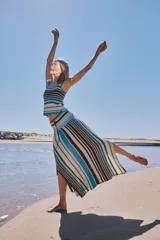 Falda larga de tejido fluido y diseño a rayas horizontales en tonos marrón, azul, amarillo y crudo, con cordón ajustable en la cintura.