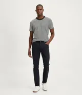 Pantalón de hombre, corte slim, color azul marino oscuro, confeccionado en sarga de algodón con elastano. Presenta cintura con trabillas, cierre por botón y cremallera, y bolsillos delanteros y traseros.