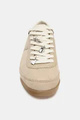 Zapatillas deportivas color beige con pespuntes en el cuerpo, parte trasera en contraste de color y cierre mediante cordones. La altura de la suela es de 2 cm.