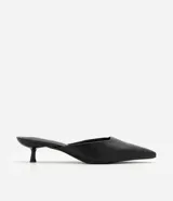 Zapato tipo mule de punta fina con tacón kitten heel bajo, confeccionado en poliuretano con acabado liso.