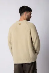 Sweater de tejido grueso con cuello redondo, mangas largas con puños acanalados y corte relajado.