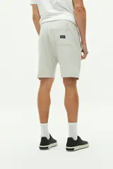 Short de felpa azul marino con textura, bolsillos laterales y uno trasero, cintura regulable con cordón y logo bordado.