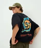 Remera de algodón con corte oversized, cuello redondo y mangas cortas. Presenta un estampado gráfico en la espalda con diseño de mapa de calor y lettering en tonos naranja y azul sobre fondo negro.