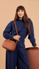 Bandolera de símil cuero color rojo, con doble bolsillo principal, un bolsillo frontal y un bolsillo trasero. Incluye correa ajustable.