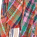 Poncho abierto de tejido de punto con diseño de rayas horizontales multicolor y patrones geométricos. Presenta terminaciones con flecos en el ruedo.